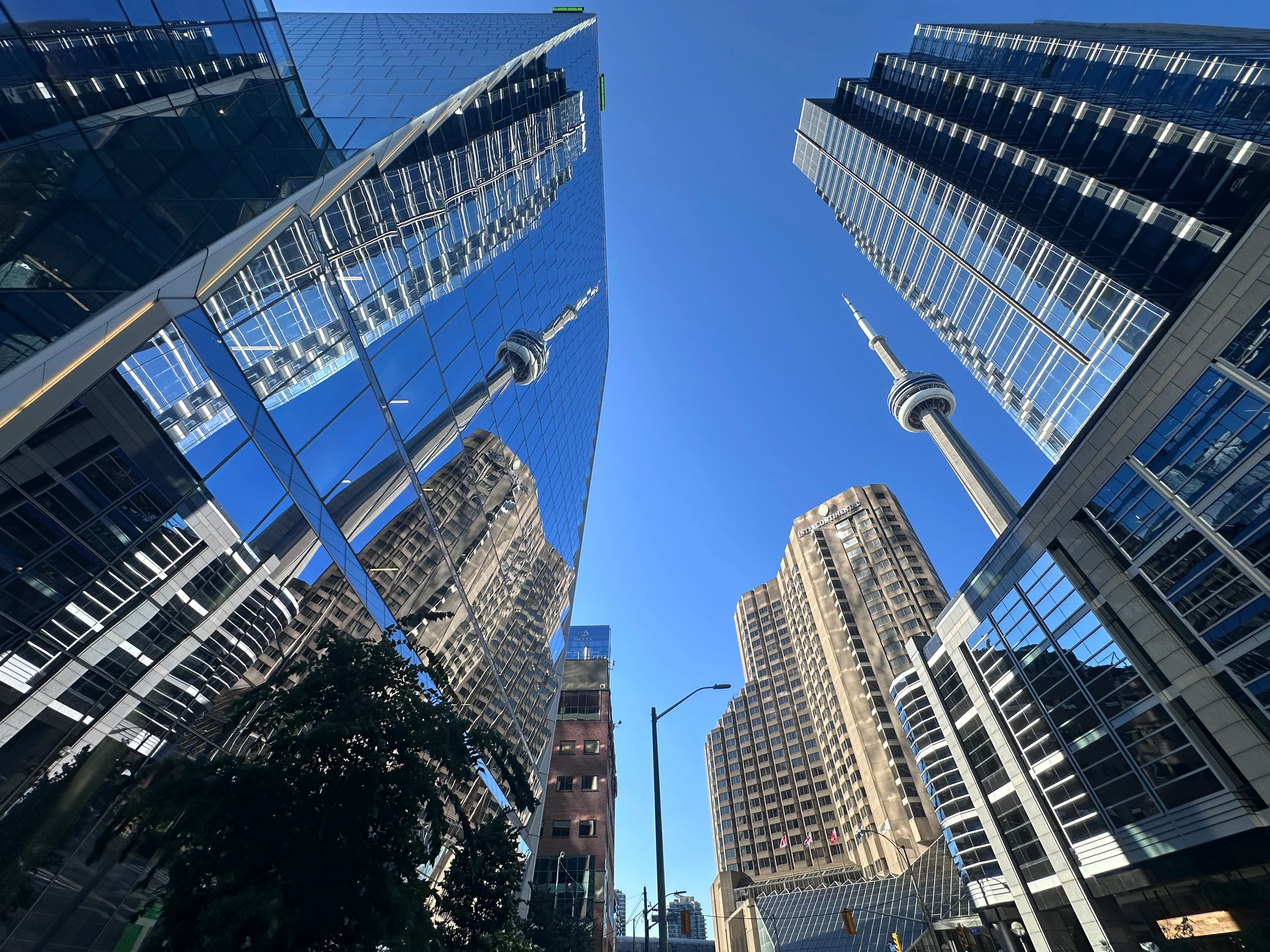 La tour CN vue en contre-plongée entre les façades vitrées — Toronto, Canada